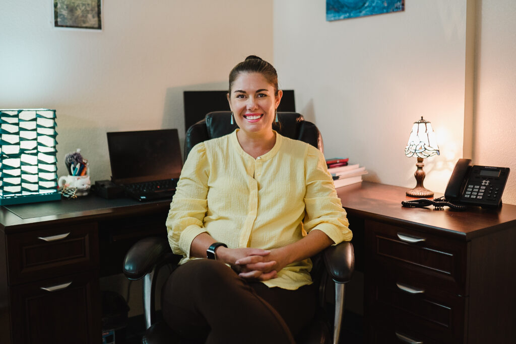 FYI+ Therapist Michelle Schilling sitting at her desk